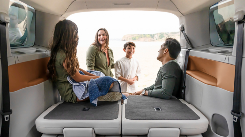 A group of four people sitting and talking inside the back of a Volkswagen ID. Buzz 2025.