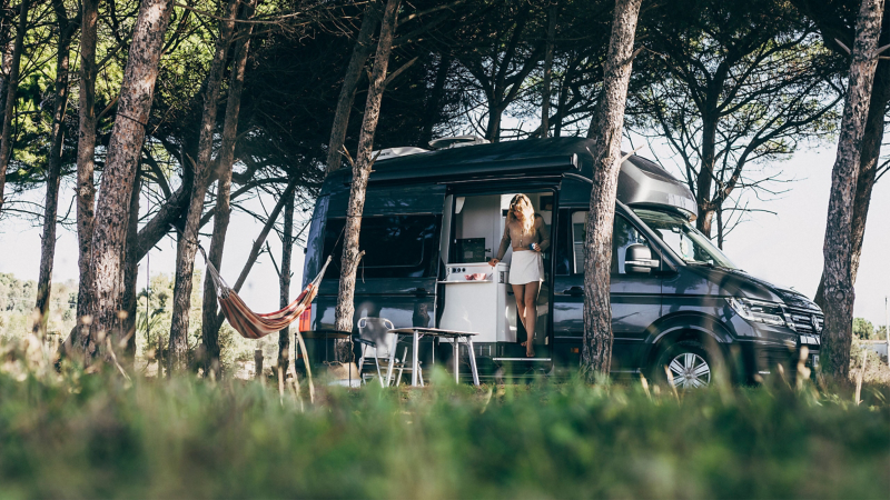 Elektrisch ausfahrbare Trittstufe des VW Grand California auf dem eine Frau aussteigt.