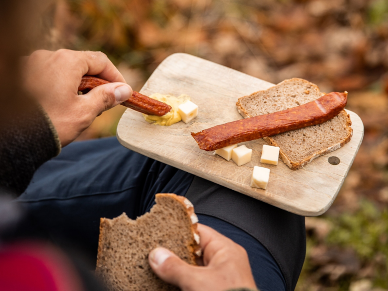 Nahaufnahme eines Frühstücksbrett auf dem Brot, Wurst und Käse liegt.