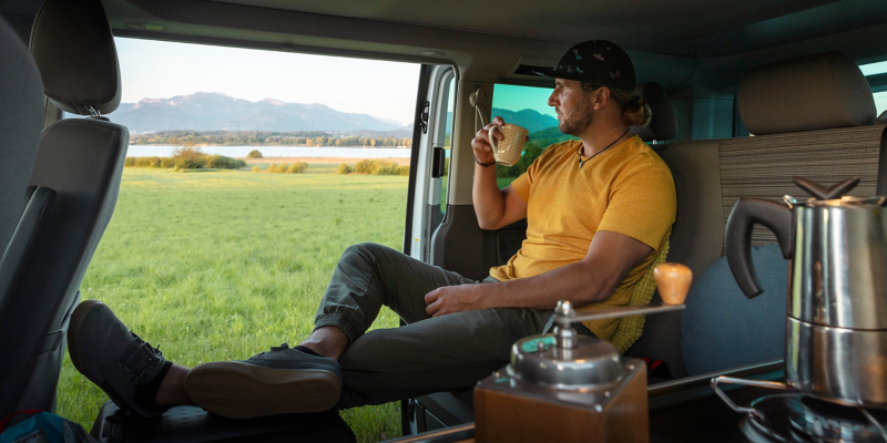 Dricker kaffe i en VW California.