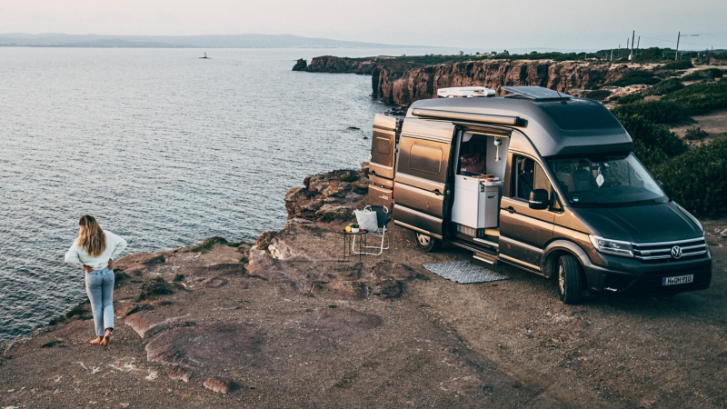VW Grand California parkerad på en klippa vid havet.