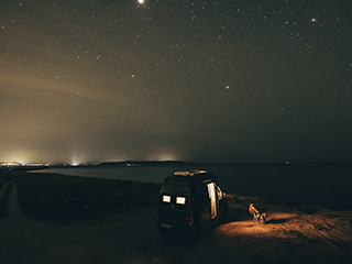 Eine Langzeitaufnahme des Himmels in der Nacht am Strand.