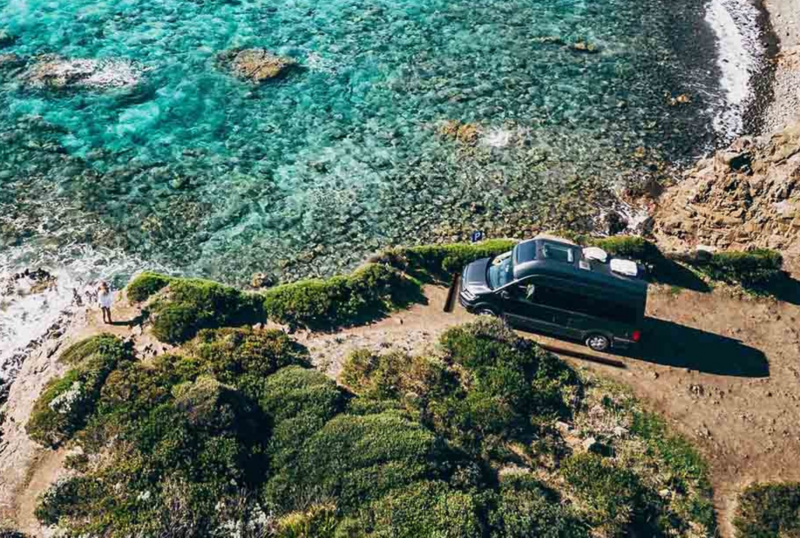 un van california vw garé près de la mer