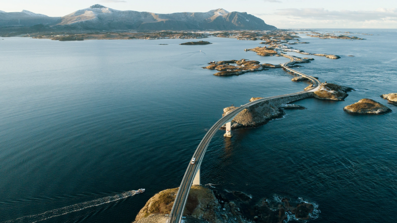 Ein Auto fährt über eine Fjord Brücke in Norwegen.
