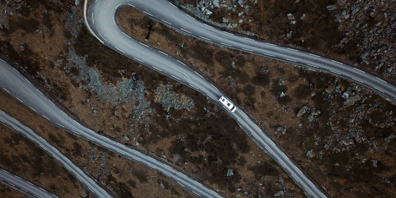 Top-Down-View auf eine Straße mit einem Fahrzeug.