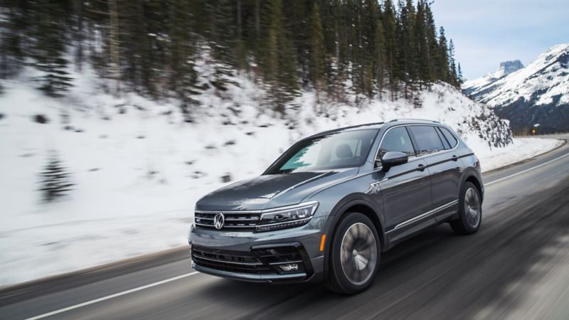 A Tiguan Highline with R-Line Package driving with snow seen in the background