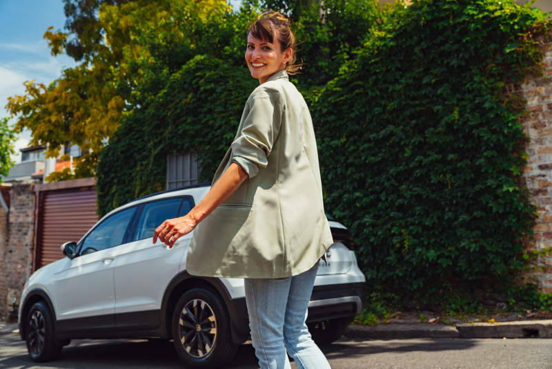 Women stood looking at camera with VW car in background