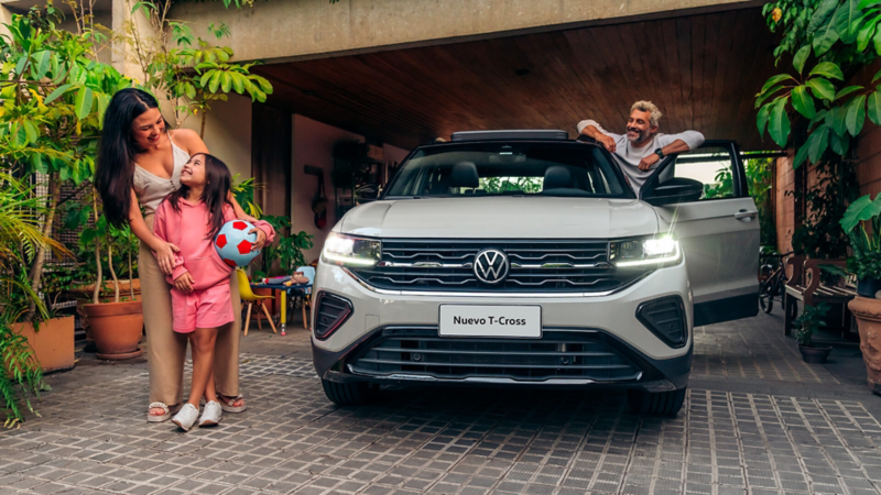 Nuevo Volkswagen T-Cross blanco frente a vivienda familiar con luces LED encendidas