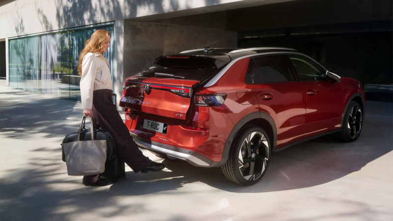 Woman opening the boot of a red VW T-Roc 