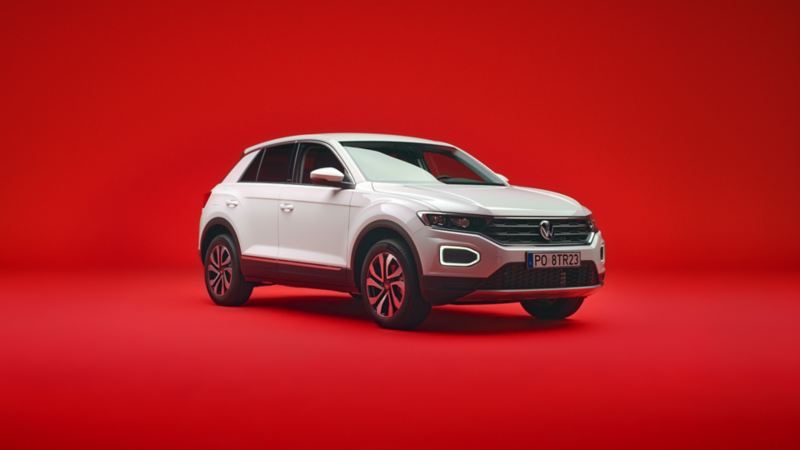 Biały VW T-Roc widziany z przodu i z boku na czerwonym tle.