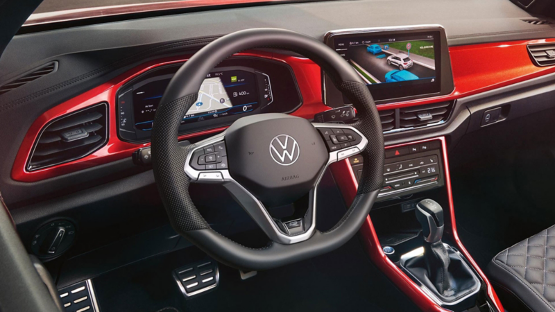 Et blik på cockpittet i den røde T-Roc Cabriolet med multifunktionsrat, radio og Digital Cockpit.