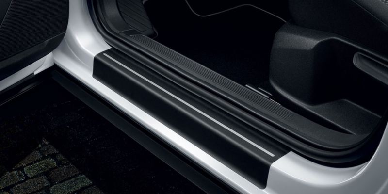 Dettaglio delle pellicole battitacco nere con strisce argento originali Volkswagen, applicate su una T-Roc.