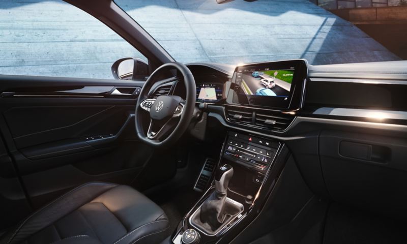 Vista degli interni di Volkswagen Nuovo T-Roc, con dettaglio sul volante multifunzione e display Digital Cockpit Pro da 10,25'', del sistema di infotainment.