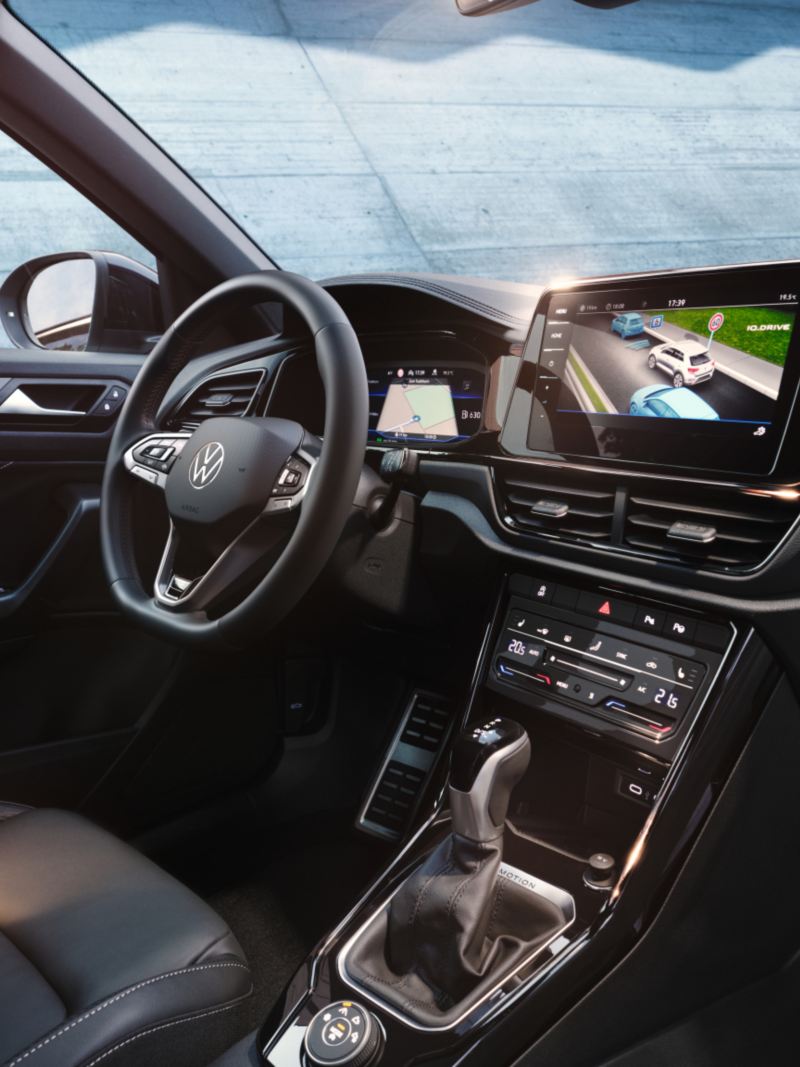 Vista degli interni di Volkswagen Nuovo T-Roc, con dettaglio sul volante multifunzione e display Digital Cockpit Pro da 10,25'', del sistema di infotainment.