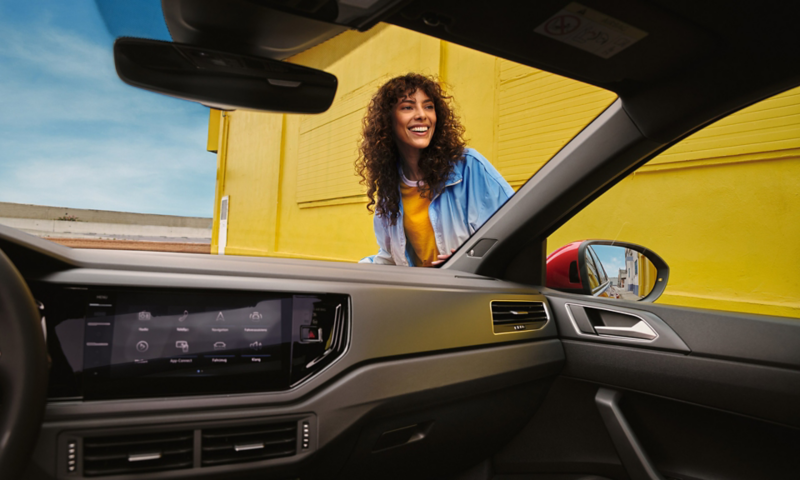 Εσωτερικό του VW Taigo R-Line: άποψη του ταμπλό και, μέσα από το μπροστινό παρμπρίζ, μιας γυναίκας.