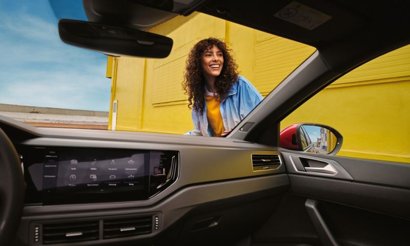 Intérieur du VW Taigo R-Line: Coup d’œil sur le tableau de bord et sur une femme à travers le pare-brise
