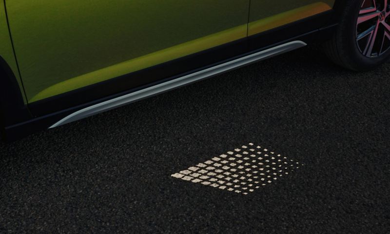 Projection lumineuse sous les portières d'un Volkswagen Taigo vert.