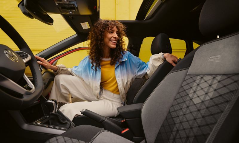 Intérieur du VW Taigo R-Line : une femme est assise sur le siège passager et regarde vers l'arrière.