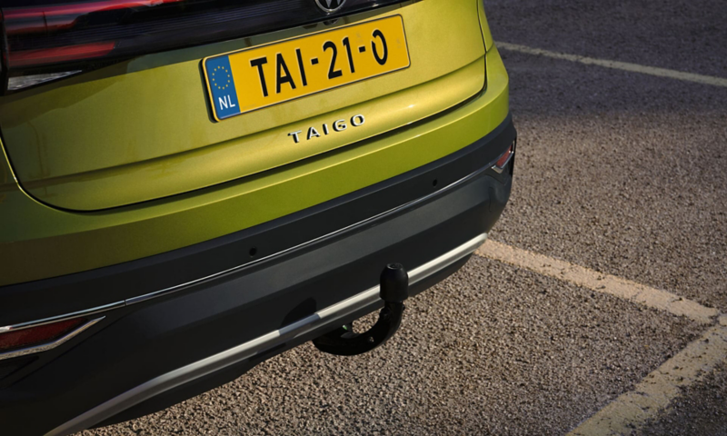 Gedetailleerde weergave van de optionele kogelkoppeling aan de achterzijde van een groene VW Taigo