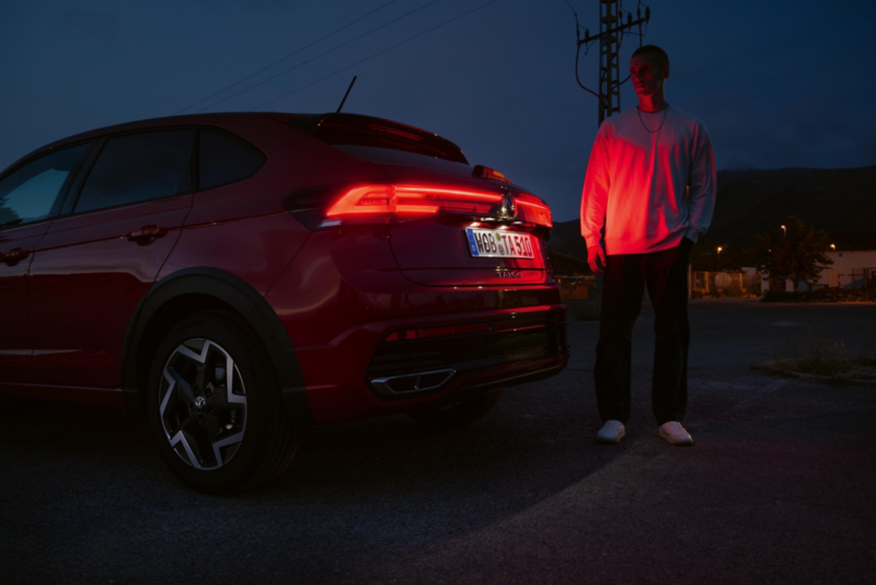 Vista posteriore di VW Taigo con gruppi ottici posteriori a LED accesi