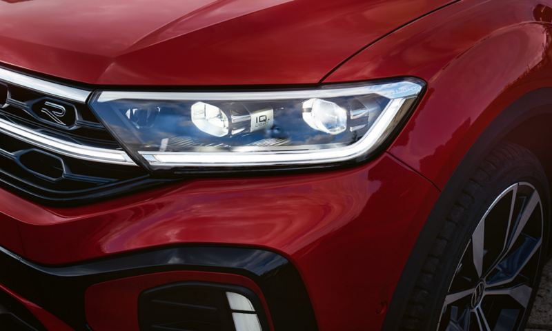 Vue détaillée du phare avant droit IQ.Light du Volkswagen T-Roc cabriolet rouge.