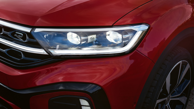 Vue détaillée du phare avant droit IQ.Light du Volkswagen T-Roc cabriolet rouge.