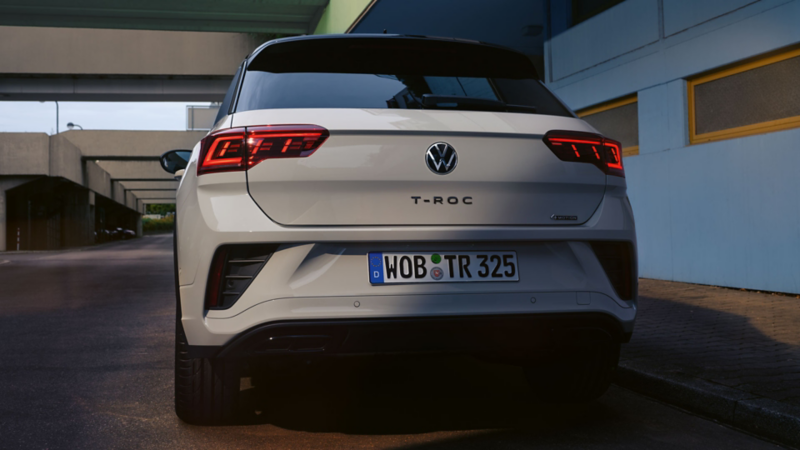 Vue arrière d’un VW T-Roc gris, garé au bord d’une route
