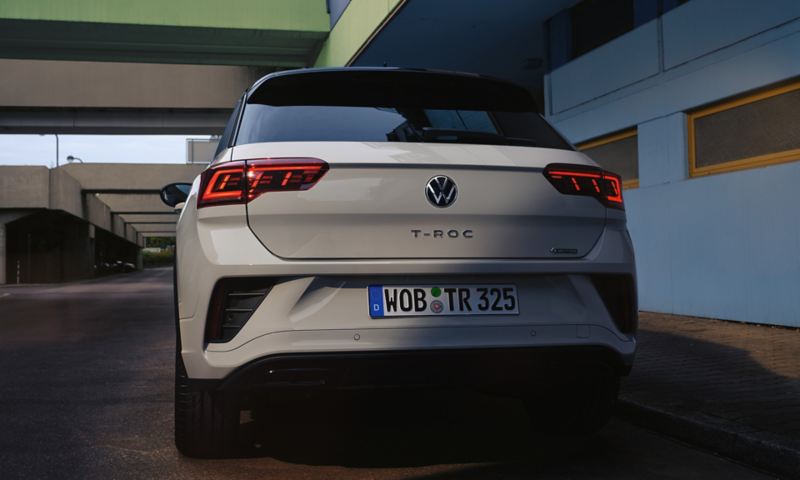 Vista posteriore di una Volkswagen T-Roc grigia parcheggiata a bordo strada
