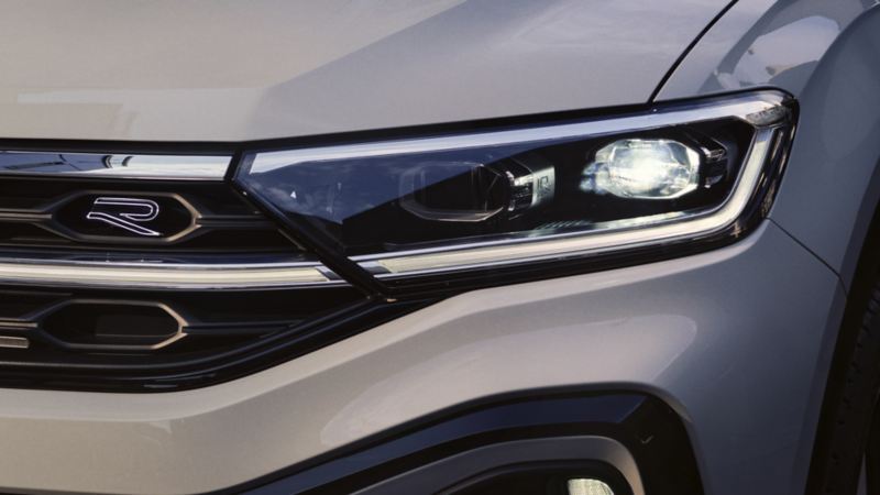 Frontansicht eines VW T-Roc R-Line in Weiß mit Fokus auf Kühlergrill und IQ.LIGHT