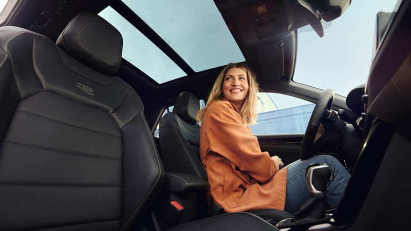 A person sitting in the driver’s seat of a T-Roc and smiling