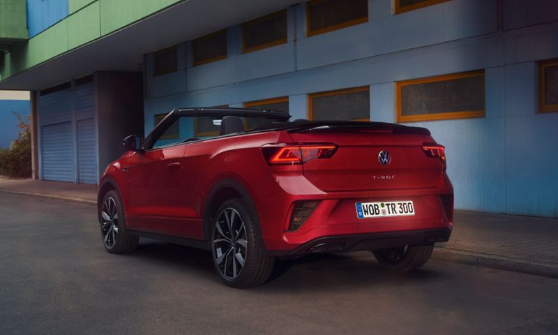 View of the rear of a red T-Roc Cabriolet with the roof open, parked on the side of the road.