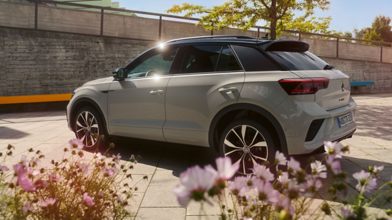 VW T-Roc in grey parked in an empty space, view of the driver’s side and the rear. 