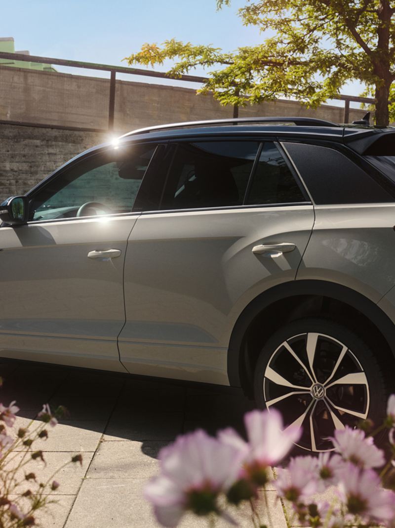 VW T-Roc in grey is parked in a space, view of the driver's side and the rear.