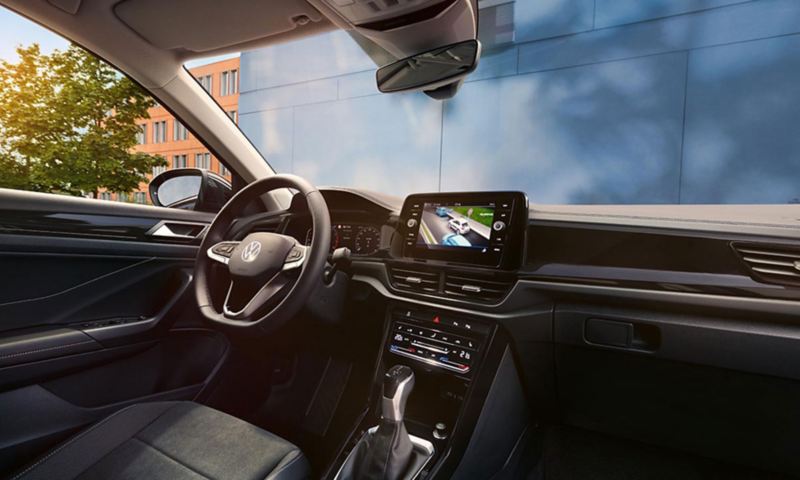 Εσωτερικό του VW T-Roc. Άποψη από το κάθισμα συνοδηγού στο κάθισμα οδηγού και τον πίνακα οργάνων, με το τιμόνι πολλαπλών λειτουργιών και το σύστημα Infotainment