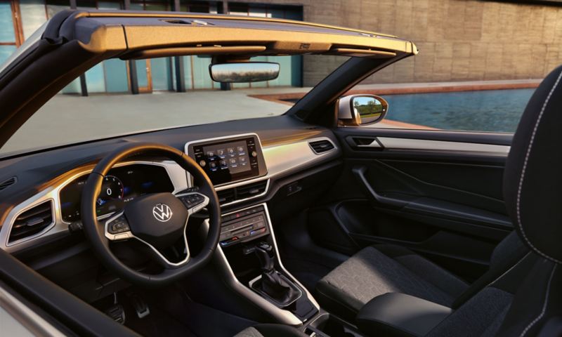 Blick auf das Cockpit des geöffneten CUV VW T-Roc Cabriolet MOVE  mit Radio „Ready 2 Discover“ und MOVE Sitzbezügen