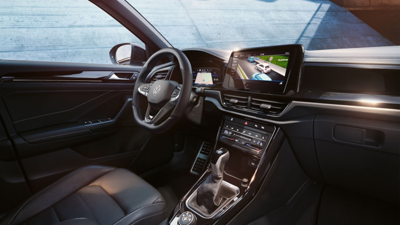  VW T-Roc interior, view from front passenger seat to driver’s seat and cockpit with multifunction steering wheel and infotainment system.