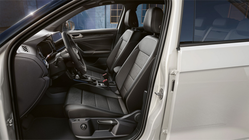 Vue depuis la portière conducteur de l'intérieur du Volkswagen T-Roc blanc. Détails des sièges ergoActive.
