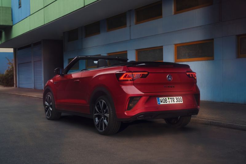 View of the rear of a red T-Roc Cabriolet with the roof open, parked on the side of the road.