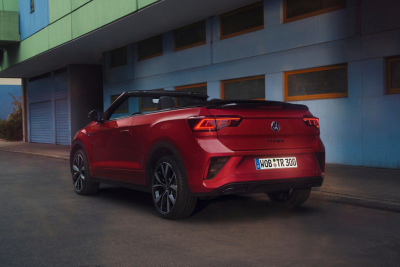 Vista posteriore di T-Roc Cabriolet con il tetto aperto, parcheggiata sul ciglio della strada.