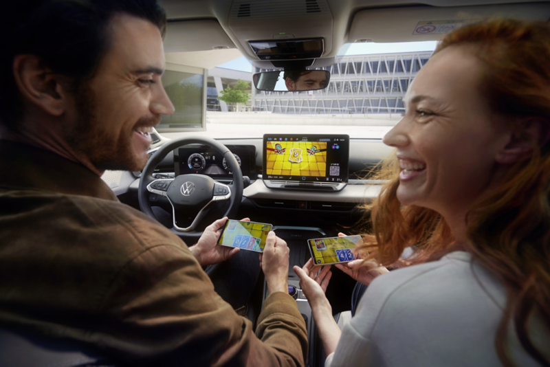 Una pareja en T-Roc Style juega Uno a través de AirConsole usando teléfonos inteligentes como controladores.