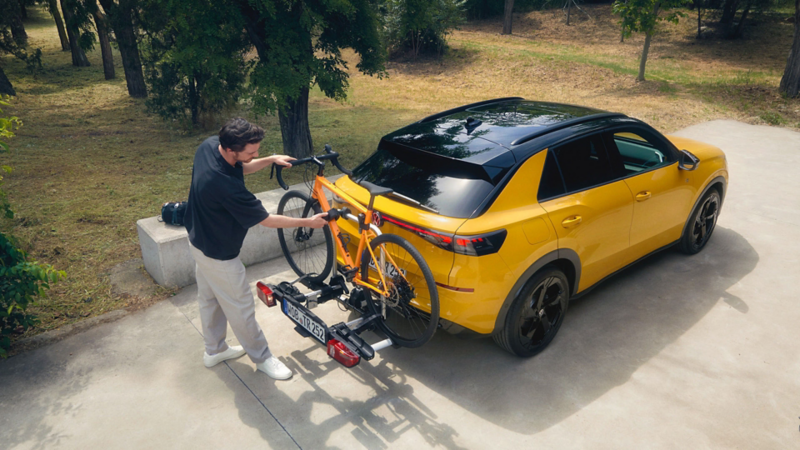 A man and a girl standing next to a white VW T-Roc