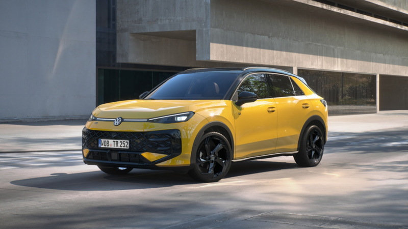 A yellow T-Roc parked on the road outside of an office building