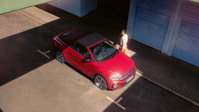 Blick von oben auf ein rotes VW T-Roc Cabriolet mit geschlossenem Verdeck.
