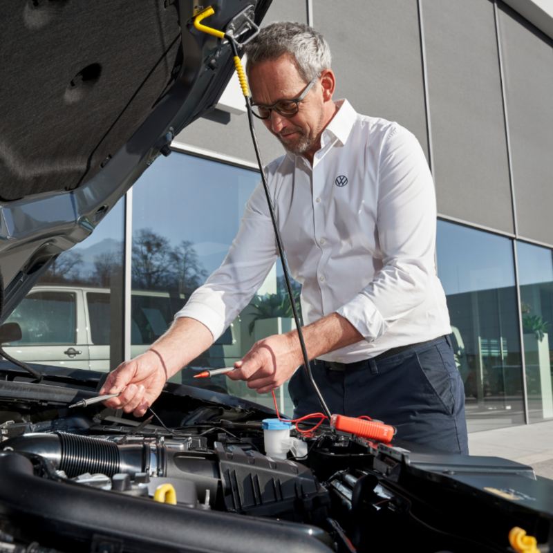Un technicien vérifie la batterie d’un véhicule Volkswagen.