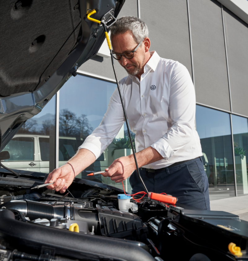 Un technicien vérifie la batterie d’un véhicule Volkswagen.