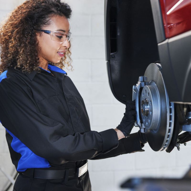 A technician checking the brake pads of a Volkswagen.