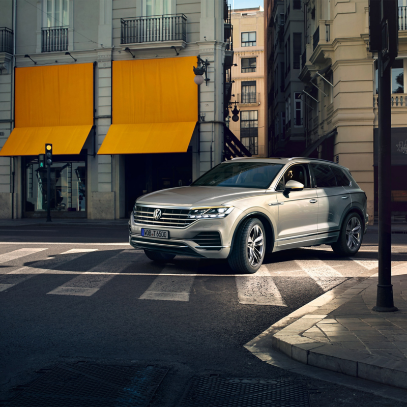 Ein Volkswagen Touareg fährt in einer Stadt um eine Kurve