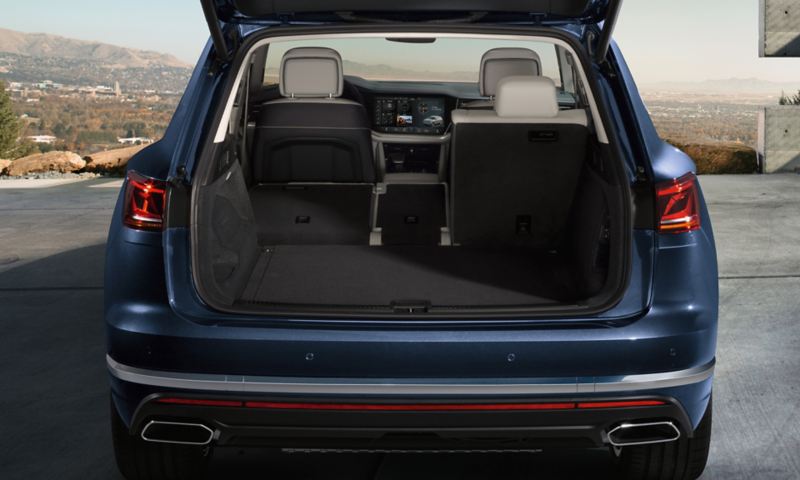 A blue VW car with open luggage compartment and folded down seat – Volkswagen luggage compartment solutions