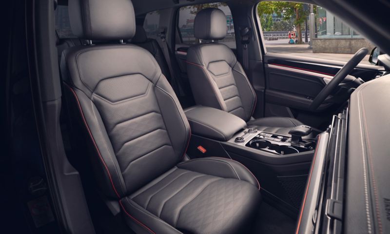 Zdjęcie detalu: przednie siedzenia w VW Touaregu „EDITION 20” obszyte skórą Savona z perforacją w romby i czerwoną lamówką.