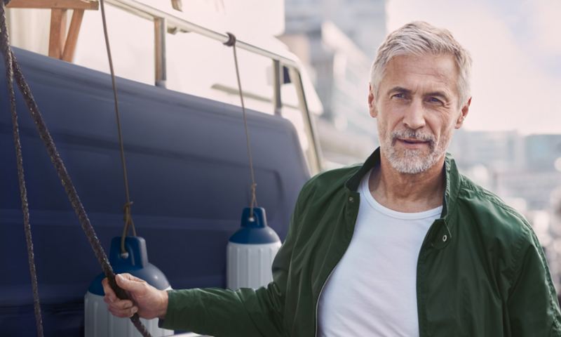 Emotion Picture, ein Mann mittleren Alters steht vor einem Boot.